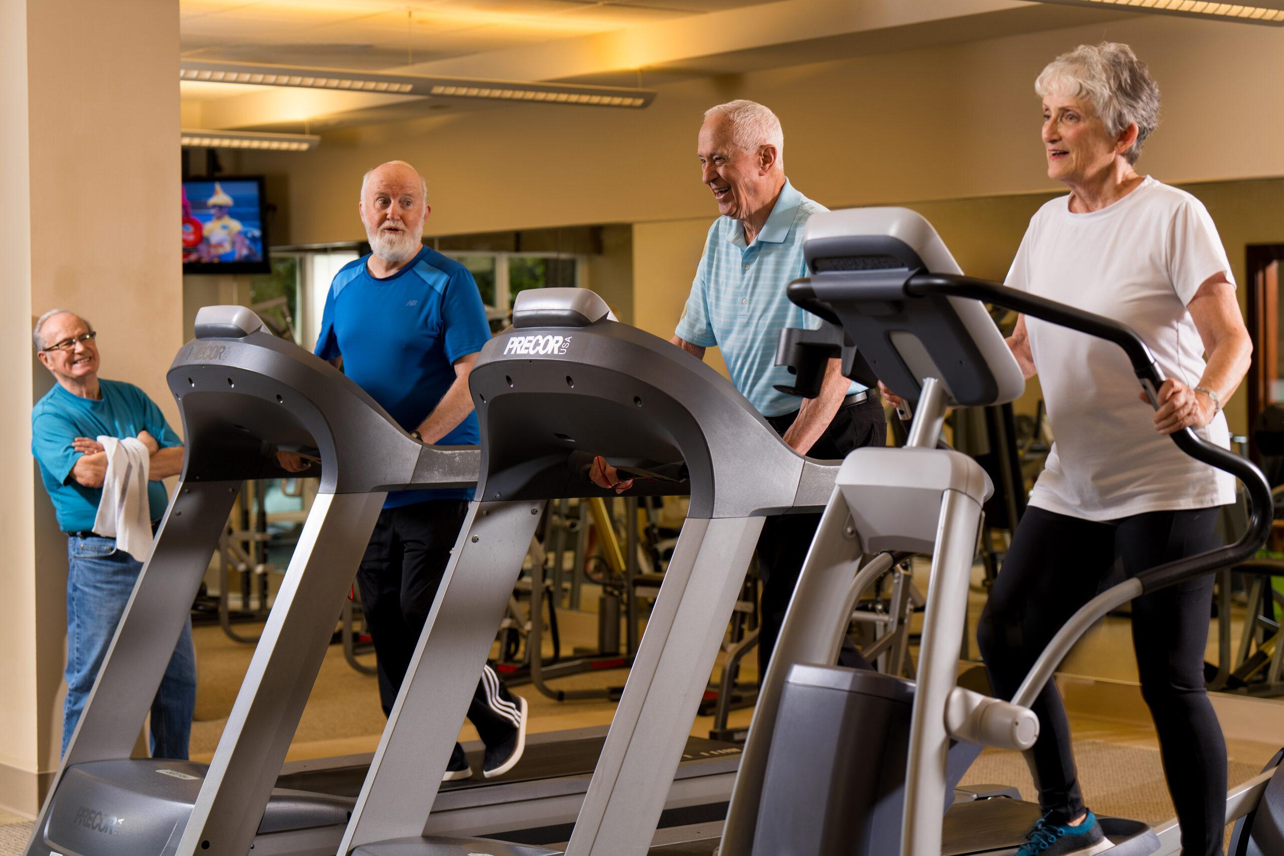 Several Mirabella Seattle residents work out on treadmills.