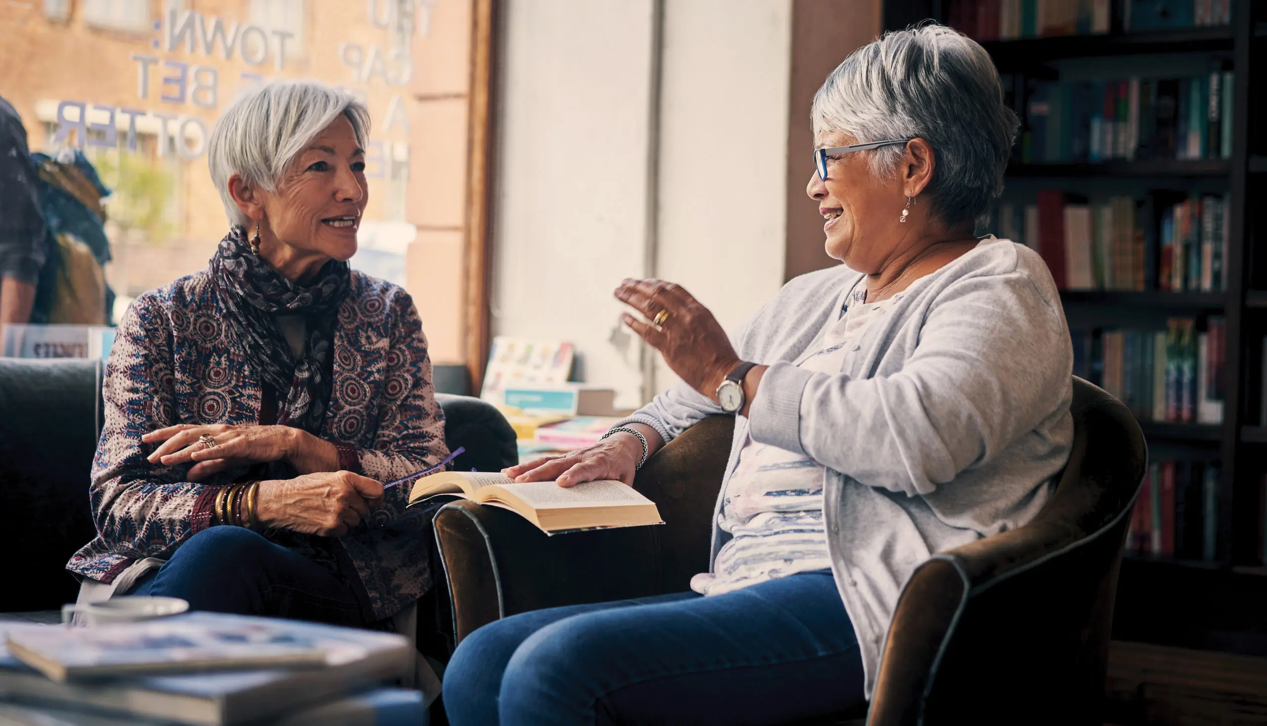 Shot of two senior women having an engaging discussion at a book club meeting in a bookstore.